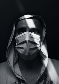 Portrait of man wearing mask against black background. just before zero hour.