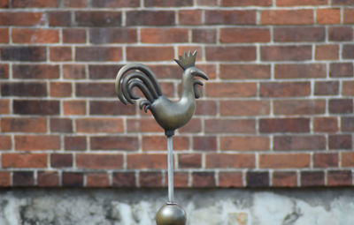 Close-up of statue against brick wall