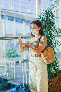Woman wearing mask using hand sanitizer