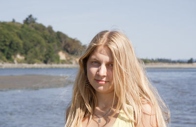 Portrait of young woman against sky