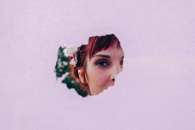 Close-up portrait of young woman against gray background