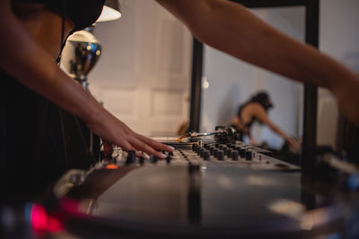 Midsection of woman playing sound mixer at home