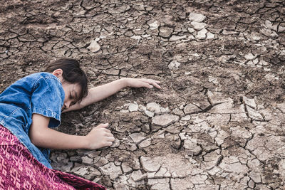 Girl lying on drought land