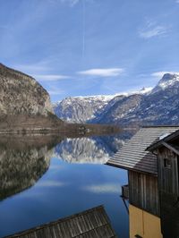 Scenic view of lake by snowcapped mountains against sky
