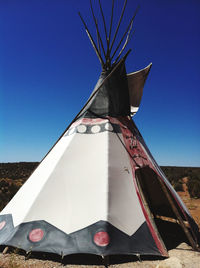 Low angle view of traditional windmill against clear blue sky