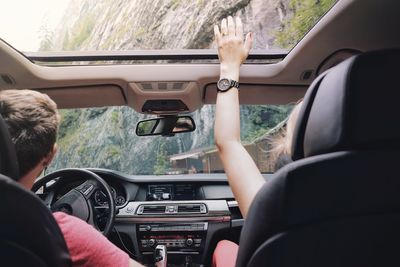 People sitting in car against mountain