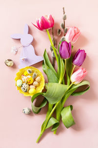 Pink and purple tulips with colorful quail eggs in a nest. spring and easter holiday concept. 