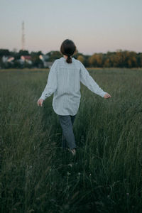 Rear view of woman standing on field