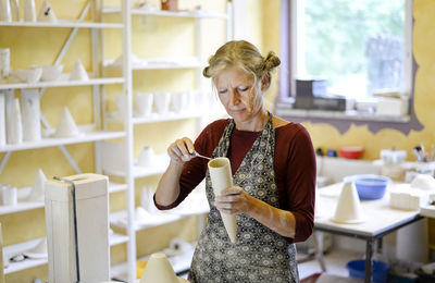 Woman working on product in porcelain workshop