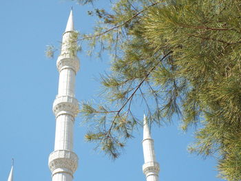 Low angle view of minarets against clear blue sky