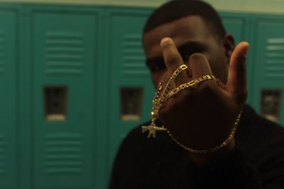 Man with gold chain showing middle finger