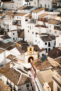 White-washed village and charming church unfold in a picturesque aerial view.