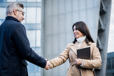 Business colleagues shaking hand outdoors