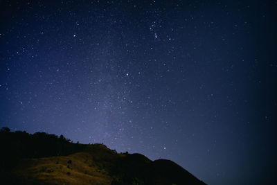 Low angle view of silhouette mountain against star field