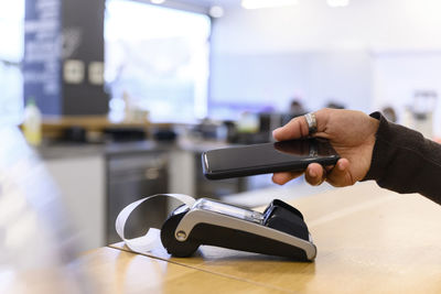 Young woman paying through mobile phone during checkout