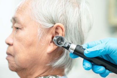 Audiologist or ent doctor use otoscope checking ear 