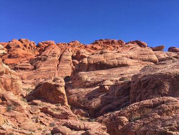 Low angle view of rock formation against clear blue sky