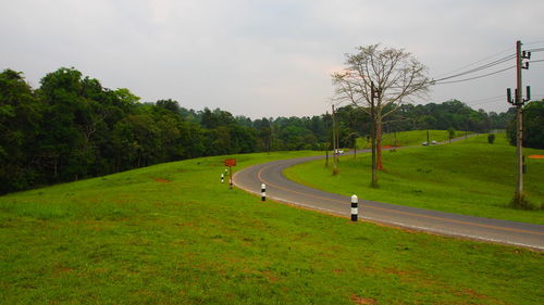 Road amidst field against sky