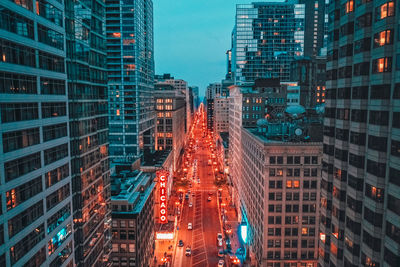 Aerial view of illuminated street amidst buildings in city