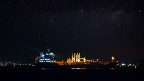 Oil ship tanker loading oil at the oil brige on the sea from refinery for transportation. at night 