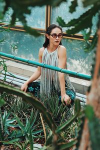 Woman wearing sunglasses against plants