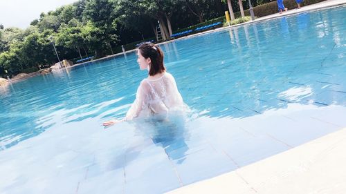 Rear view of young woman in swimming pool