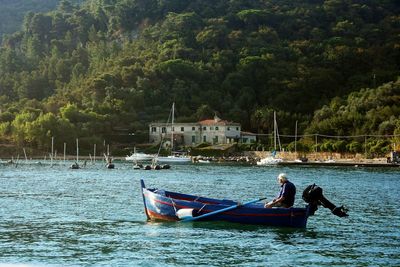 Boat moored on sea against trees