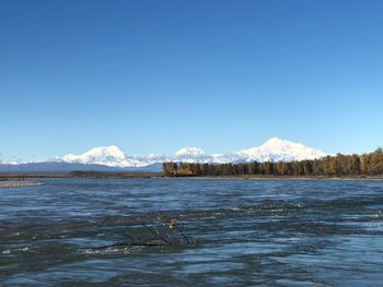 Scenic view of snowcapped mountains against clear blue sky