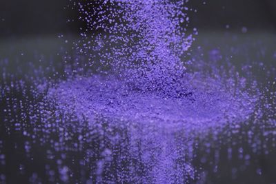 Purple mineral falling on glass