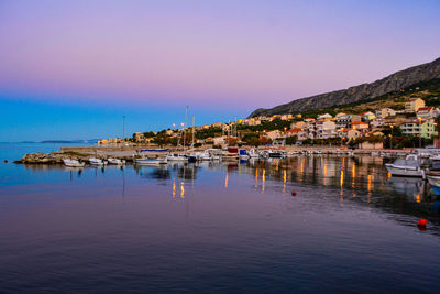 View of buildings by sea against clear sky