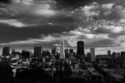 Modern cityscape against cloudy sky