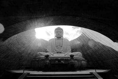 Buddha statue in temple against sky