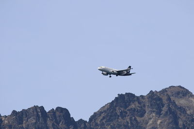 Low angle view of airplane flying against sky