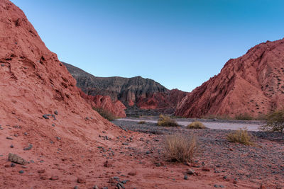 Scenic view of arid landscape against clear blue sky