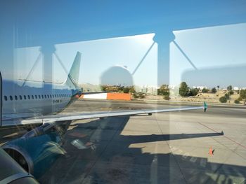 Airplane on airport runway against sky