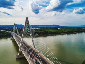 Bridge over river against cloudy sky