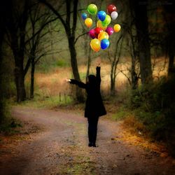 Woman with balloons in forest