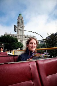 Portrait of smiling young woman against building