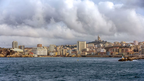 Panoramic view of sea and buildings against sky