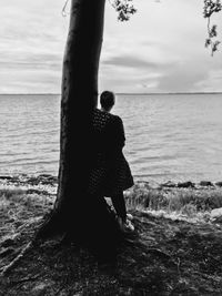 Woman looking at sea against sky