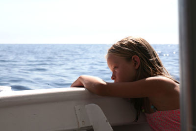 Girl looking at sea against sky