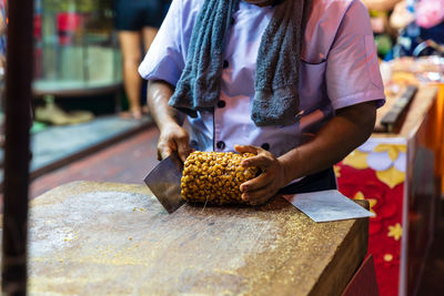 Cook show how to make peanut and sesame brittle or kanom toob tub on yaowarat street food
