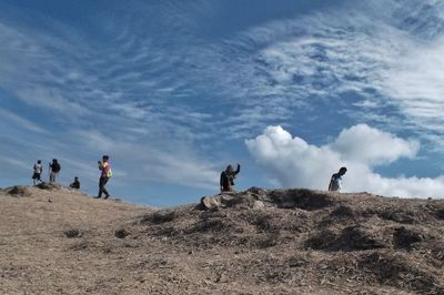 People on mountain against sky