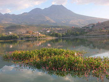 Scenic view of lake by mountains against sky