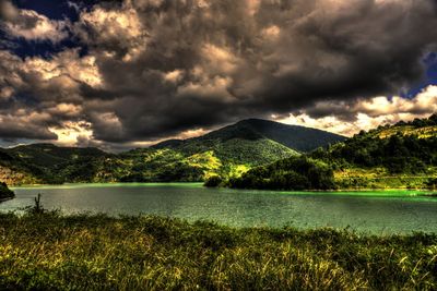 Scenic view of lake against dramatic sky