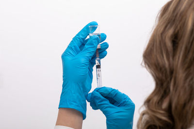 Rear view of woman holding umbrella against white background