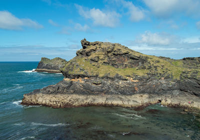 Rock formations by sea against sky