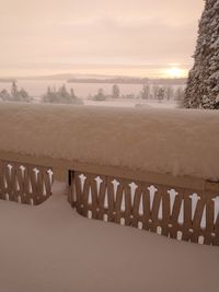 Scenic view of snow covered landscape against sky during sunset