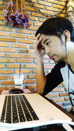 Frustrated man wearing headphones looking at laptop