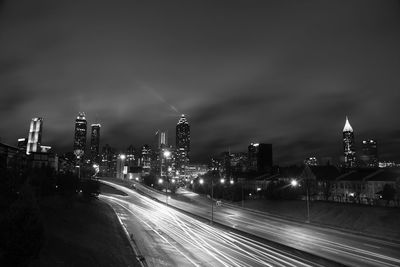 Illuminated buildings in city against sky at night